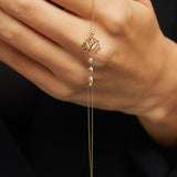 14K gold bracelet with lotus flower charm and faceted gemstone beads on emerald green satin background