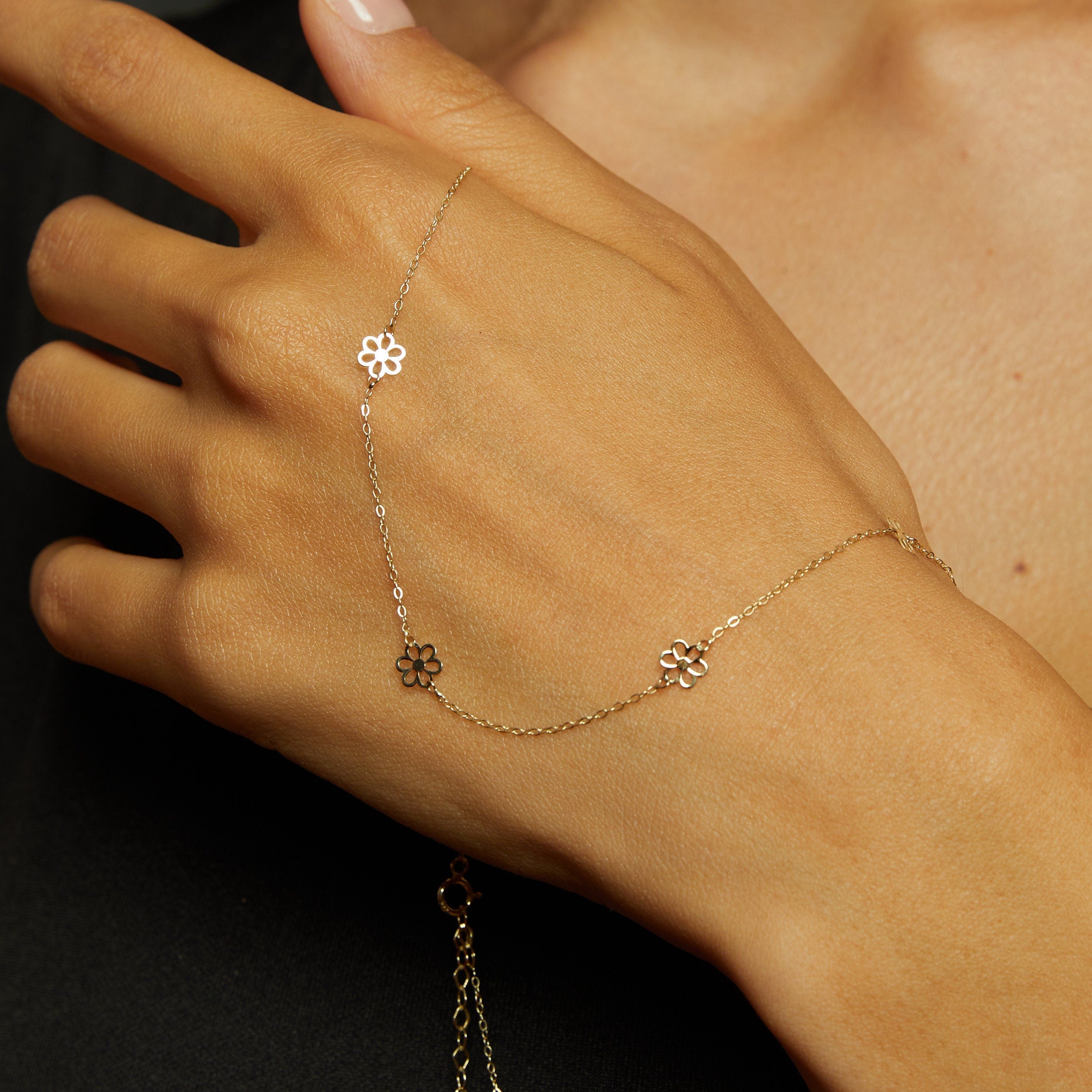 14K gold necklace featuring evenly spaced cut-out flower charms on a delicate chain