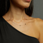 14K gold necklace featuring evenly spaced cut-out flower charms on a delicate chain