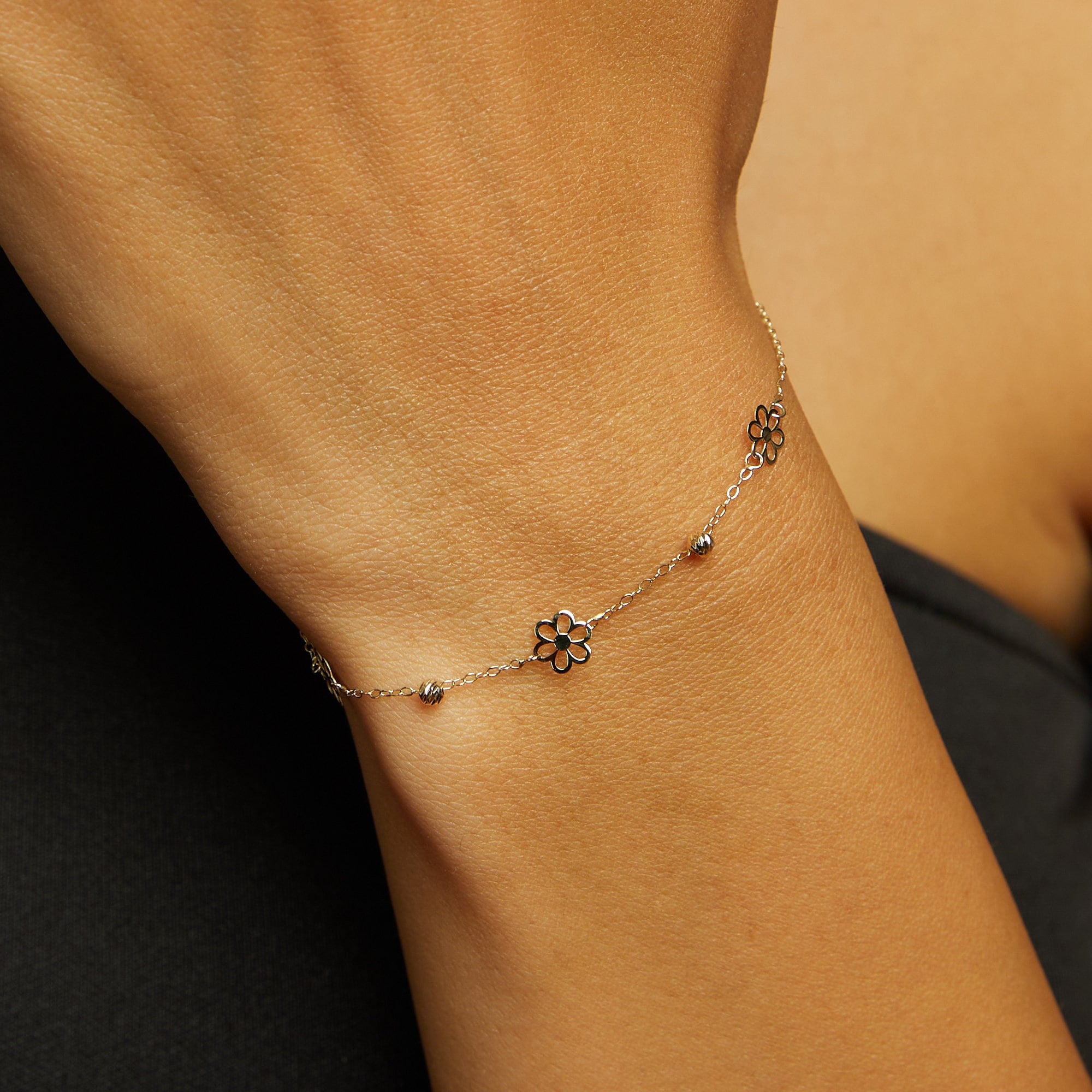 14K gold bracelet featuring three dainty flower charms and bead accents