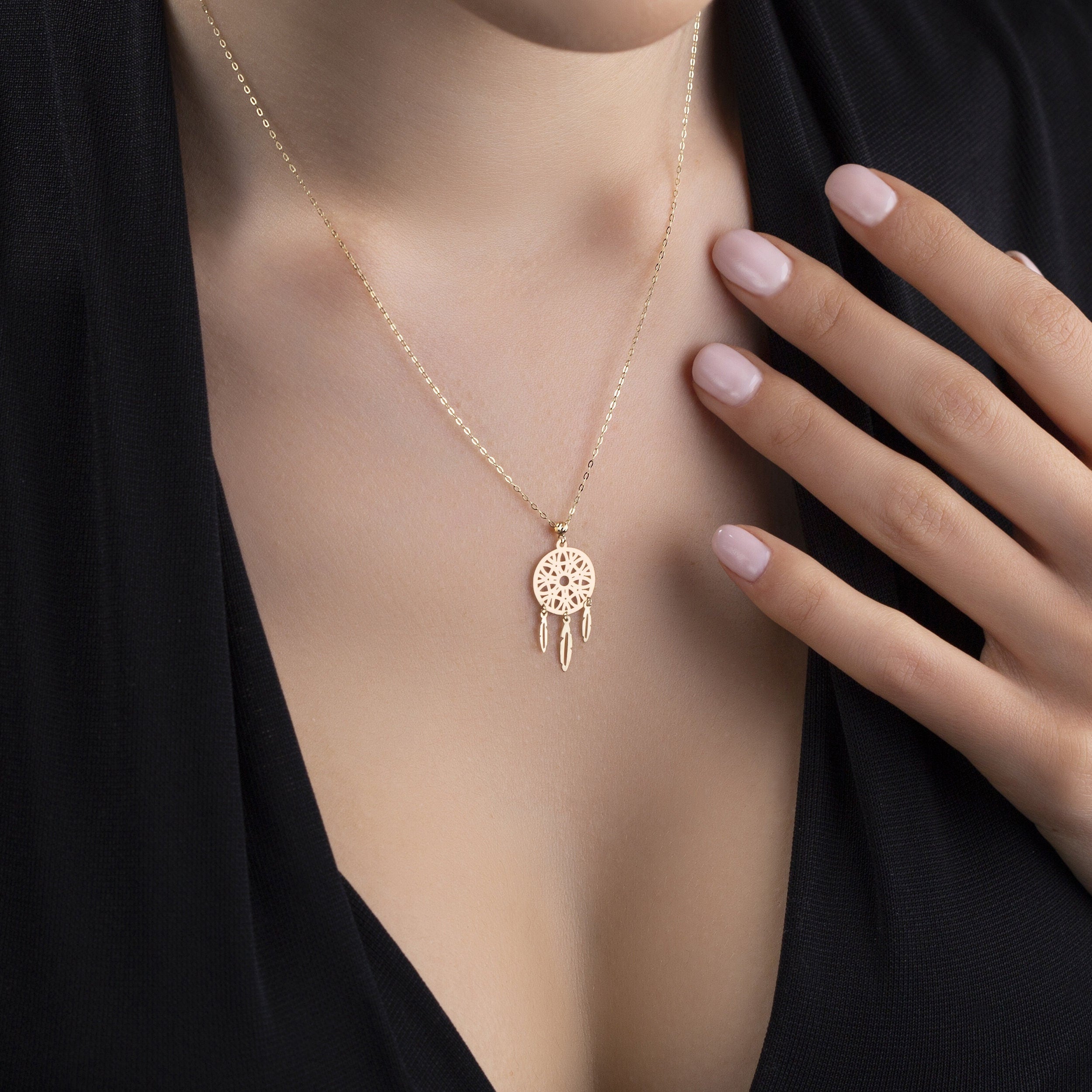 Delicate 14K gold dreamcatcher necklace with intricate circular web and three gold feather charms