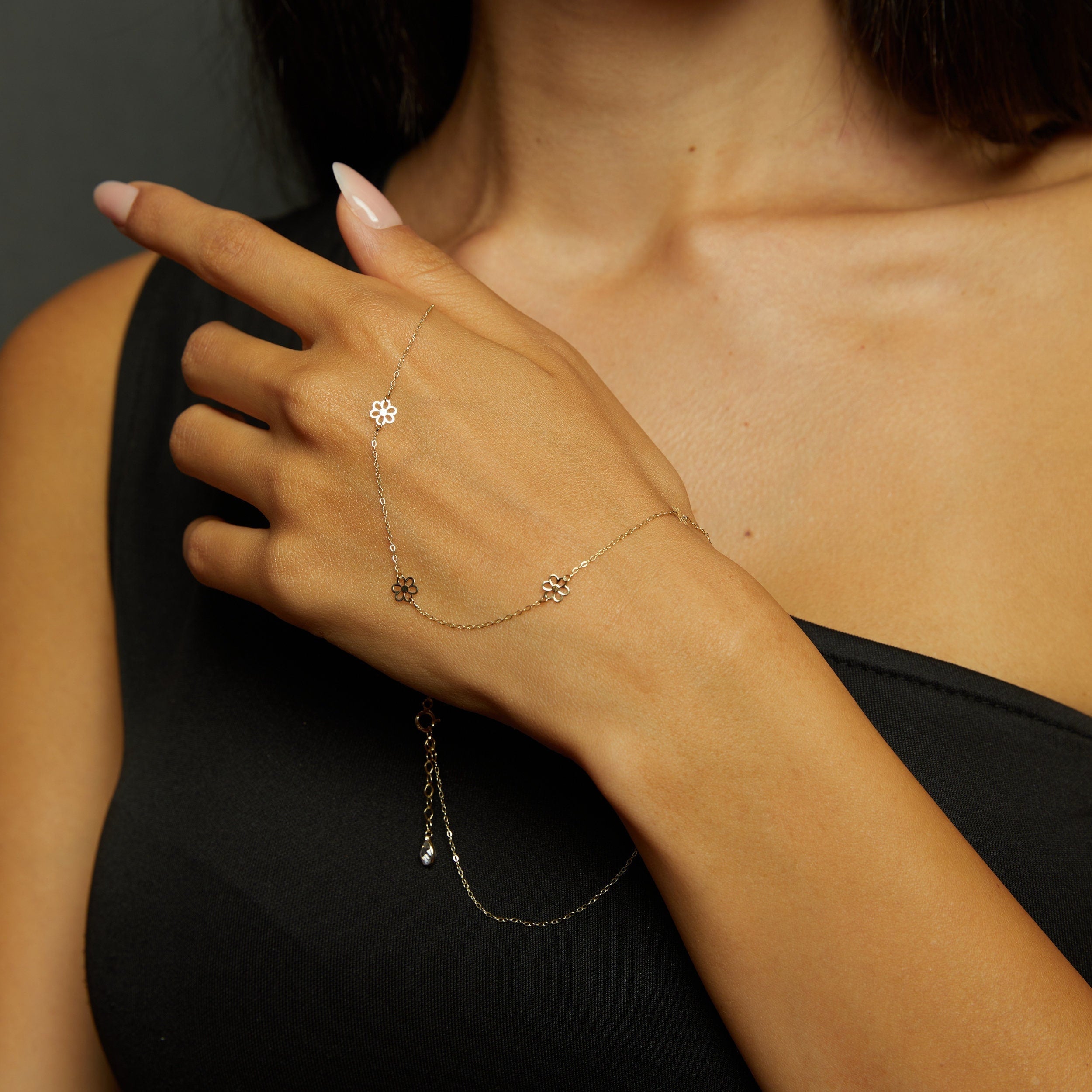 14K gold necklace featuring evenly spaced cut-out flower charms on a delicate chain