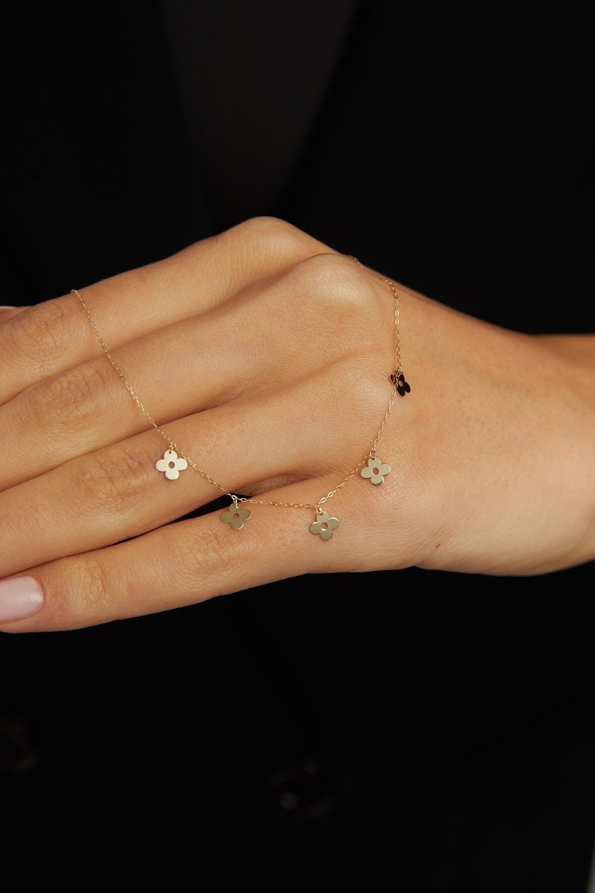 14K gold necklace featuring multiple four-leaf clover charms,