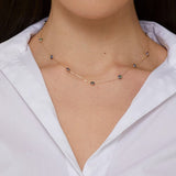 14K gold necklace with five blue and yellow enamel evil eye charms, representing protective jewelry.