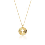 Minimalist 14K gold medallion necklace with a central cutout cross and radiant sunbeam engravings
