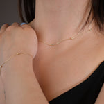 Minimalist 14K solid gold necklace with round beads spaced along a fine chain,