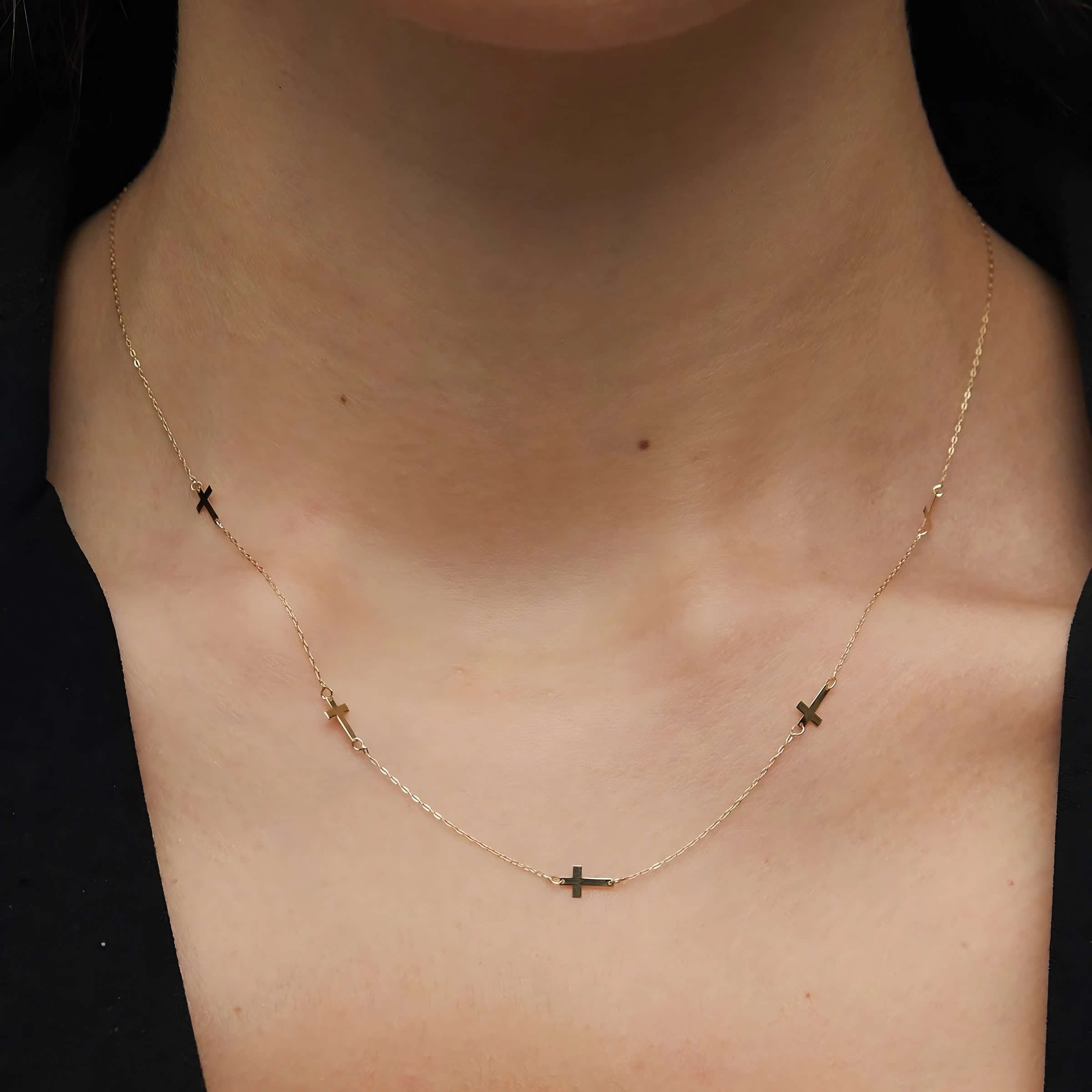 14K gold necklace with multiple small cross charms elegant and minimalistic.
