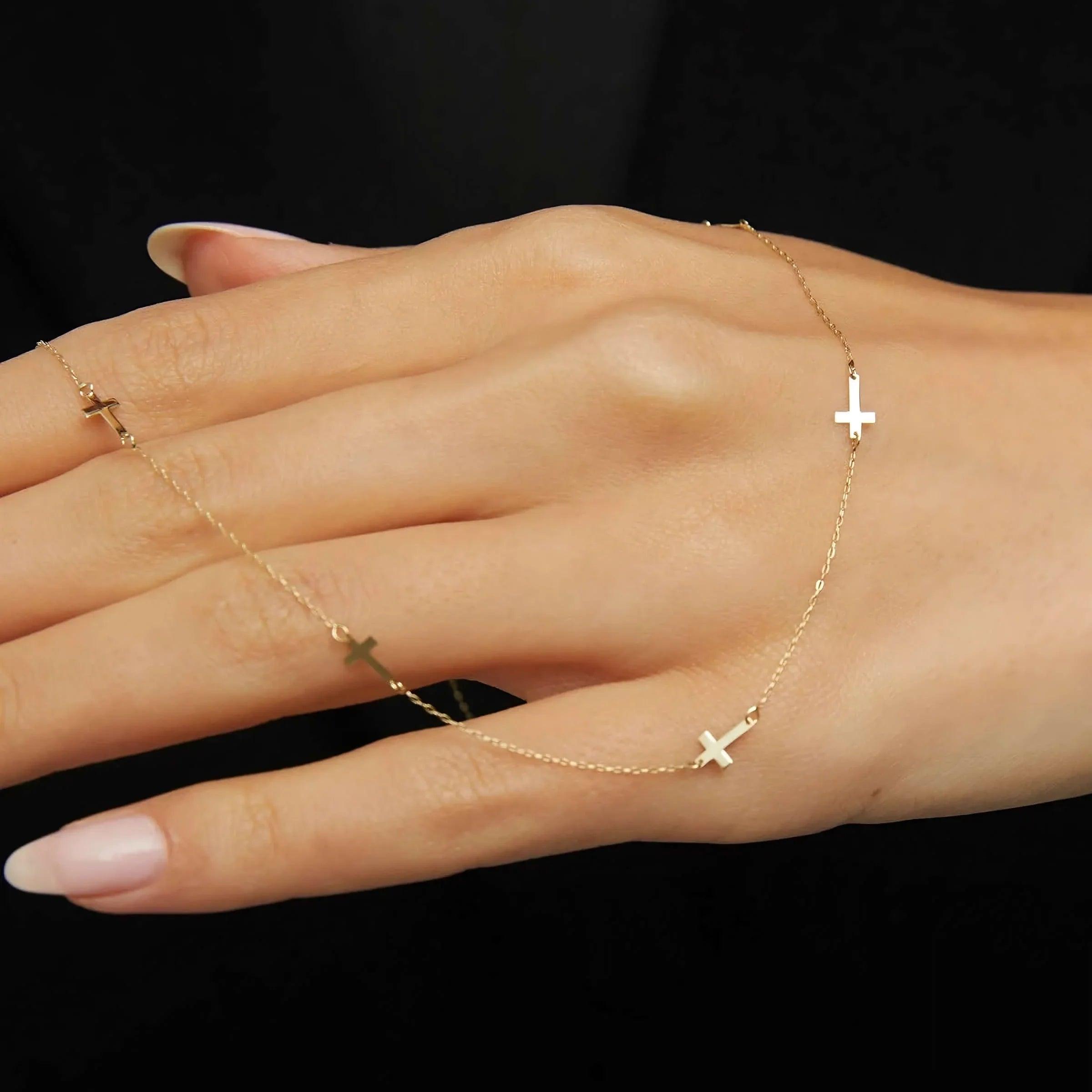 14K gold necklace with multiple small cross charms elegant and minimalistic.