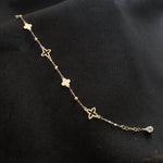 Elegant 14K gold bracelet featuring alternating solid and hollow clover charms with gold bead accents