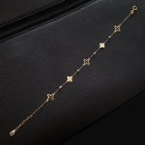 Elegant 14K gold bracelet featuring alternating solid and hollow clover charms with gold bead accents