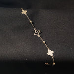 Elegant 14K gold bracelet featuring alternating solid and hollow clover charms with gold bead accents