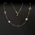 14K gold necklace with alternating solid and open clover charms on a delicate chain