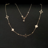 14K gold necklace with alternating solid and open clover charms on a delicate chain