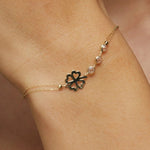 14K gold bracelet with four-leaf clover charm and gemstone details