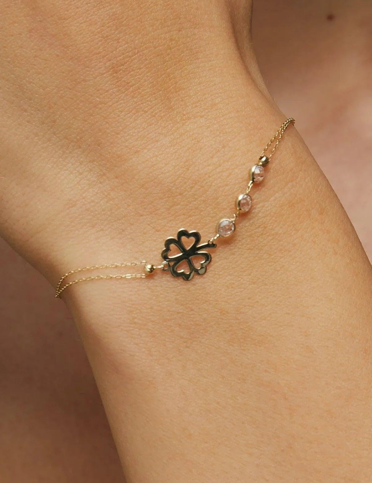 14K gold bracelet with four-leaf clover charm and gemstone details