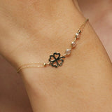 14K gold bracelet with four-leaf clover charm and gemstone details