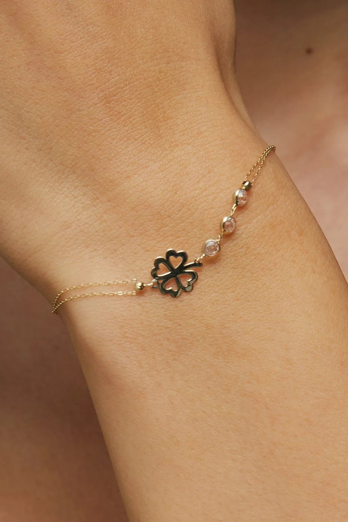 14K gold bracelet with four-leaf clover charm and gemstone details