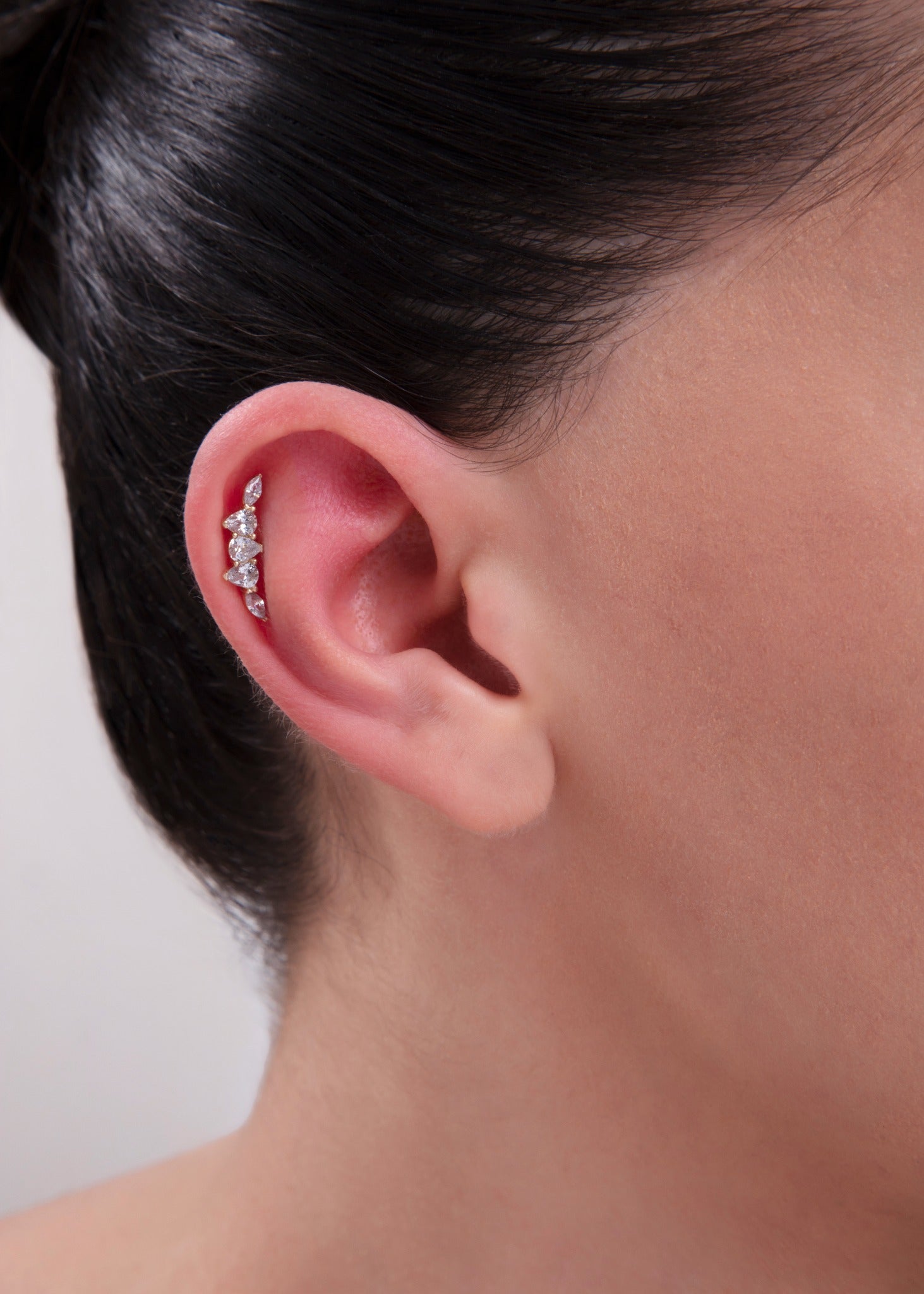 Model wearing a 14K Gold Curved Marquise CZ Helix Stud – Elegant five-stone cartilage earring with alternating marquise and teardrop-shaped cubic zirconia, designed to follow the curve of the helix.